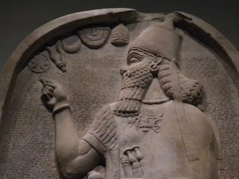 Maltese cross, and solar discs pendants on the limestone stela of Ashurnasirpal II